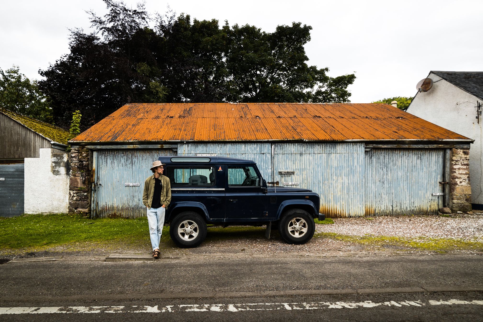 Man standing against Land Rover defender. 