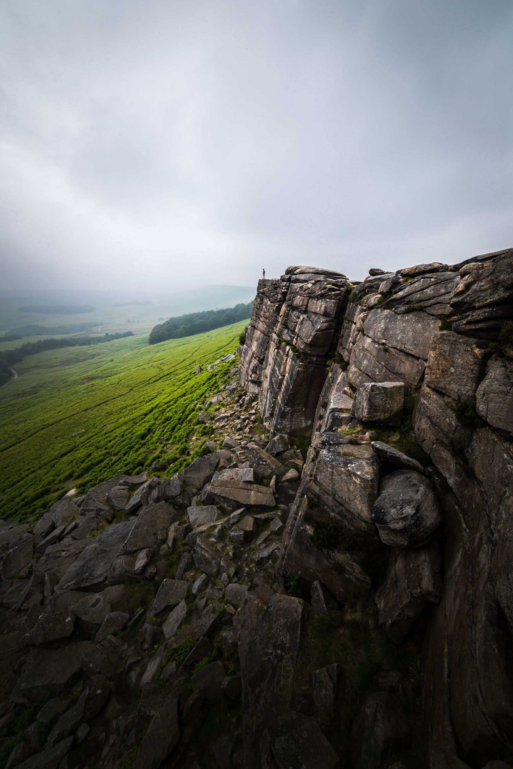 Man in the distance standing on small cliff face. 