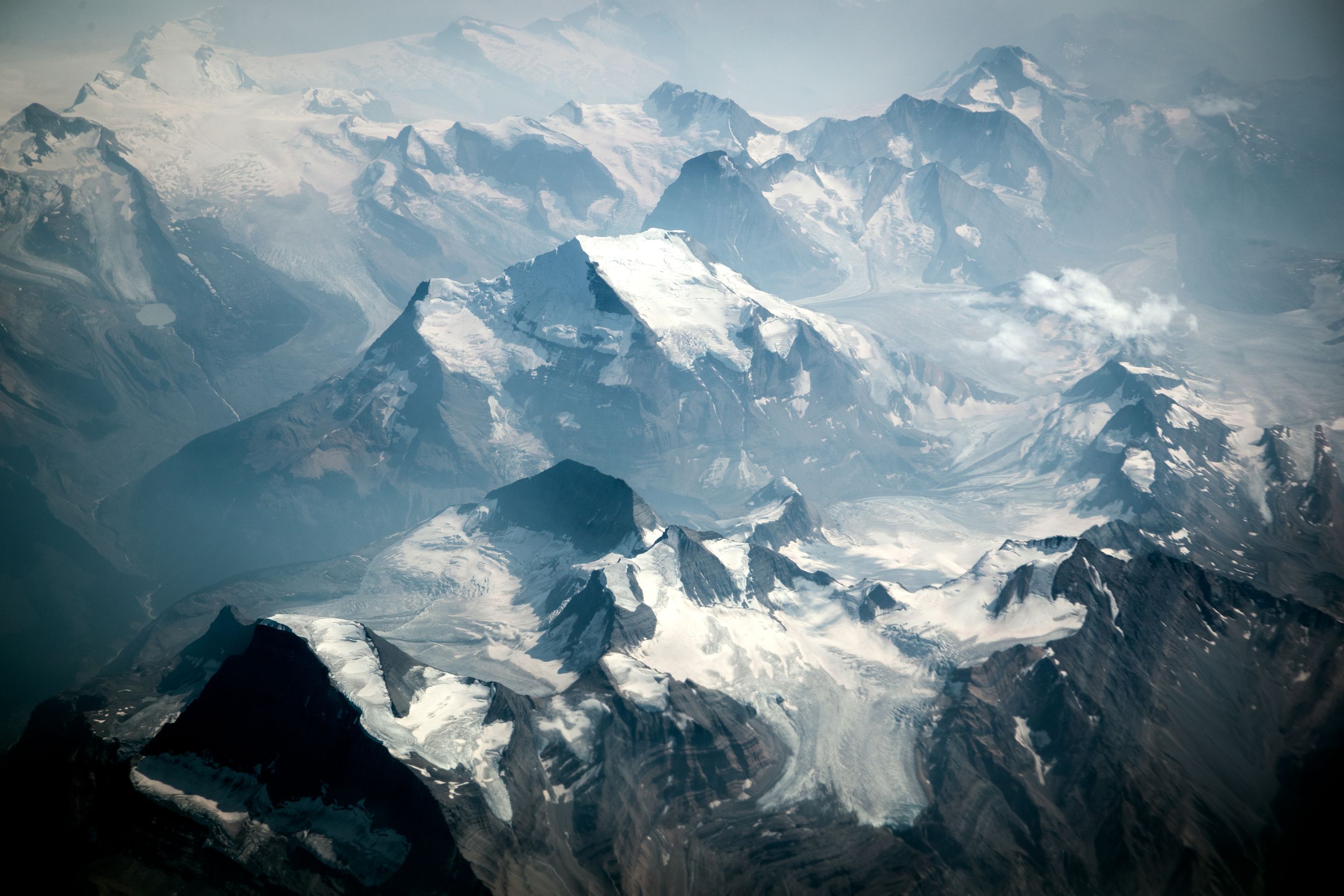 Aerial shot of rocky and snowy mountain peaks.